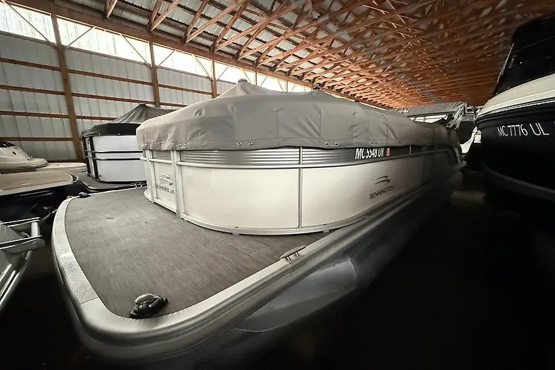 Slide: The Image of 2021 Bennington 25 SSBXSD pontoon boat covered in storage facility. - 5