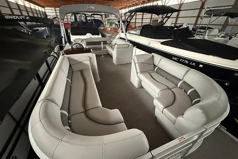 Slide: The Image of 2021 Bennington 25 SSBXSD pontoon boat with spacious seating in a covered storage area. - 8