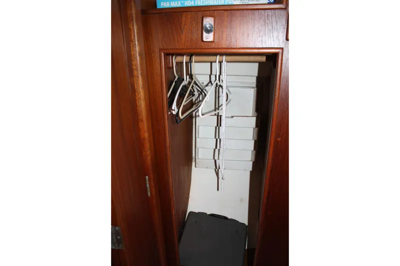 Slide: The Image of Wooden closet interior with hangers and storage boxes on a 1983 Cape Dory 27 sailboat. - 19