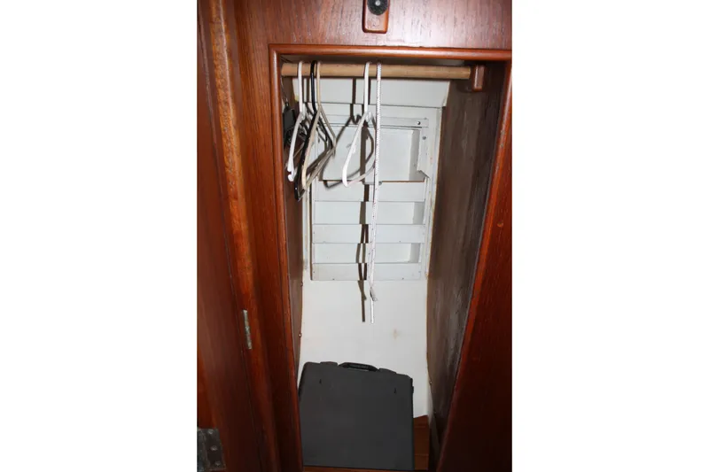 Slide: The Image of Wooden closet interior on a 1983 Cape Dory 27 sailboat, featuring hangers and storage space. - 20