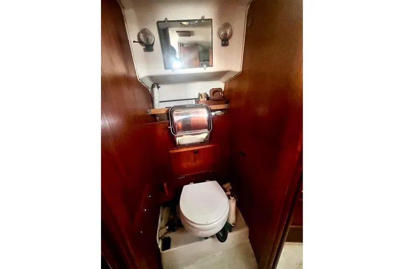 Slide: The Image of Compact bathroom in 1983 Cape Dory 27 sailboat with wooden cabinetry and marine toilet. - 22