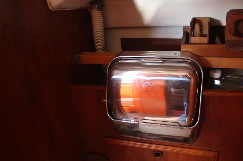Slide: The Image of Interior of a 1983 Cape Dory 27 sailboat featuring a compact stainless steel oven. - 23