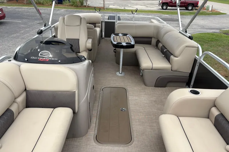 Slide: The Image of 2023 Sun Tracker Party Barge 22 DLX interior with plush seating and table. - 19