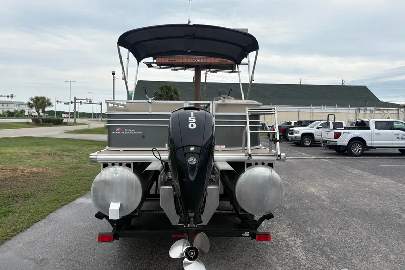 Slide: The Image of 2023 Sun Tracker Party Barge 22 DLX pontoon boat with 150 HP engine, parked outdoors. - 2