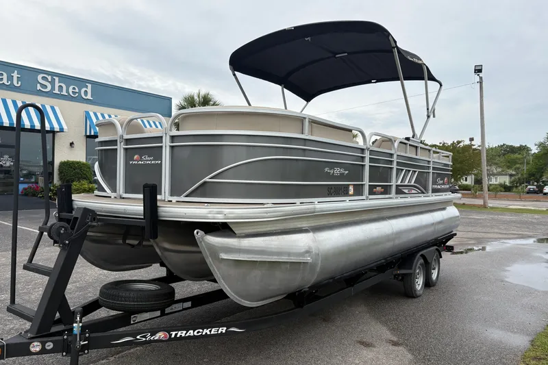 Slide: The Image of 2023 Sun Tracker Party Barge 22 DLX pontoon boat on trailer outside dealership. - 7