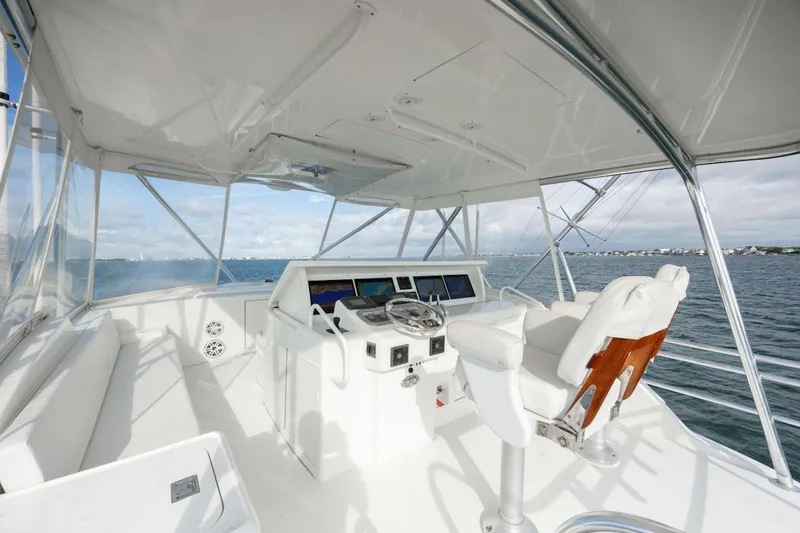 Slide: The Image of Helm of 2003 Hatteras 60 Convertible yacht with ocean view and modern controls. - 15