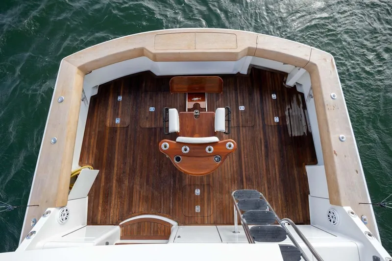 Slide: The Image of 2003 Hatteras 60 Convertible yacht deck with wooden flooring and fishing chair. - 17