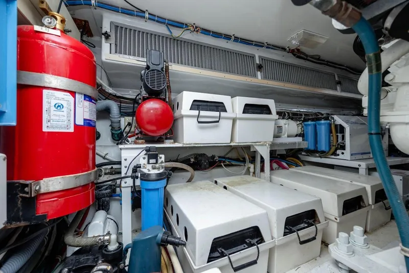 Slide: The Image of Engine room of 2003 Hatteras 60 Convertible yacht with equipment and fire extinguisher. - 22