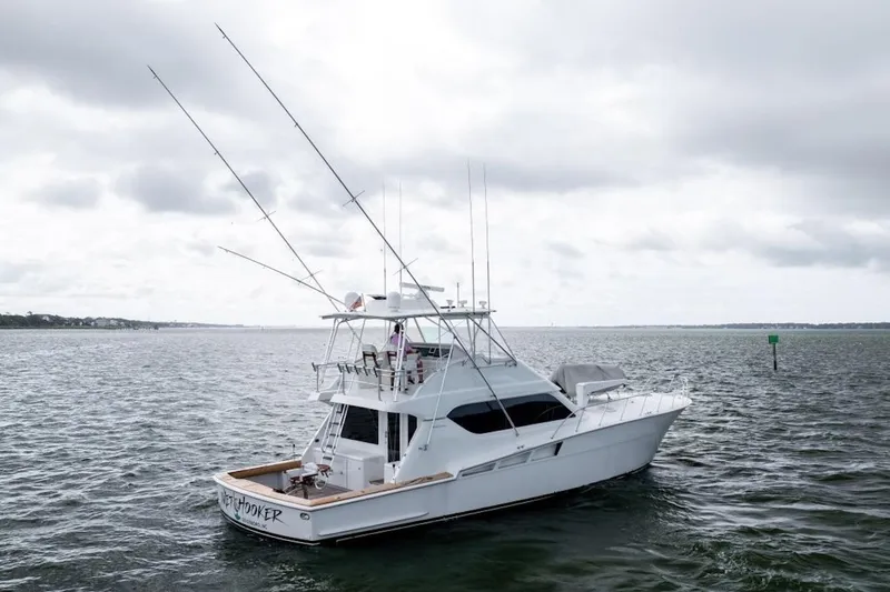 Slide: The Image of 2003 Hatteras 60 Convertible yacht on open water under cloudy skies. - 5