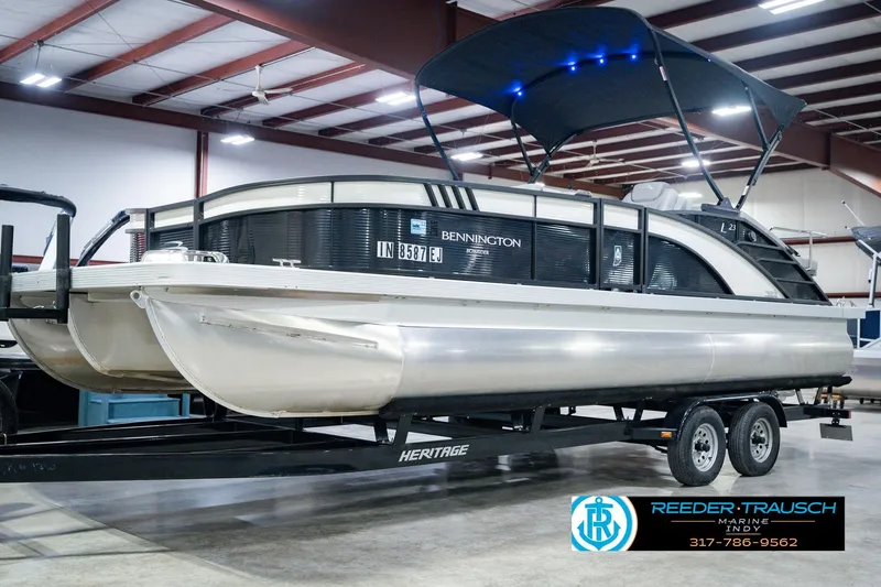 Slide: The Image of 2022 Bennington 23 LTSB pontoon boat on trailer in indoor showroom. - 2