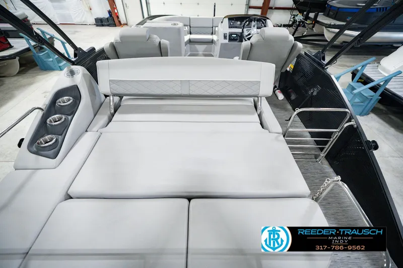 Slide: The Image of 2022 Bennington 23 LTSB boat interior with plush seating and cup holders in showroom. - 22