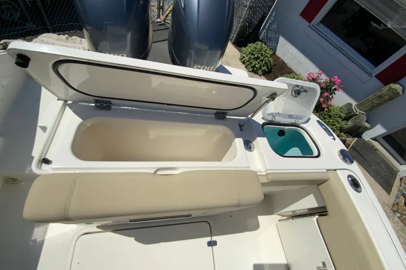 Slide: The Image of 2021 Pursuit DC 266 Dual Console boat with open storage and sink, outdoor setting. - 12