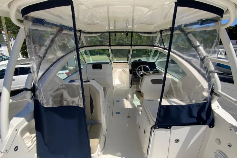 Slide: The Image of 2021 Pursuit DC 266 Dual Console boat interior with clear canopy and seating. - 14
