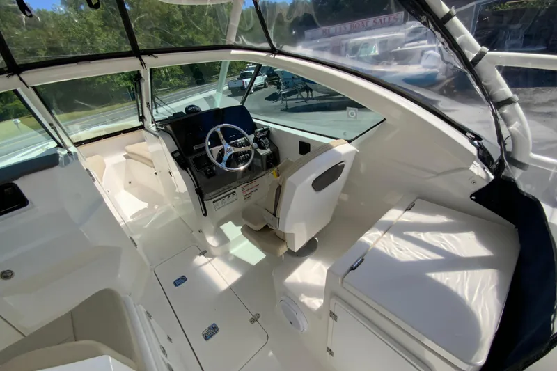 Slide: The Image of 2021 Pursuit DC 266 Dual Console boat interior with steering wheel and seating area. - 15