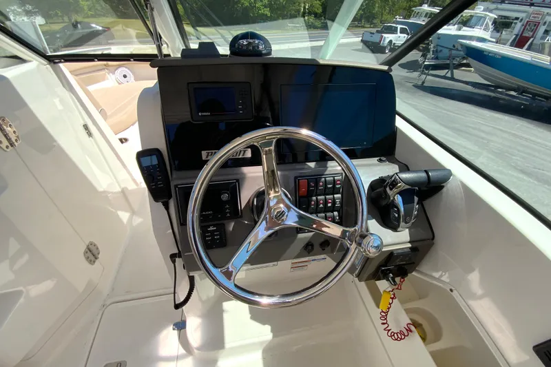 Slide: The Image of 2021 Pursuit DC 266 Dual Console boat helm with steering wheel and control panel. - 17
