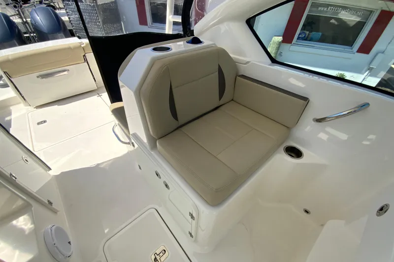 Slide: The Image of 2021 Pursuit DC 266 Dual Console boat interior with beige seating and cup holders. - 18