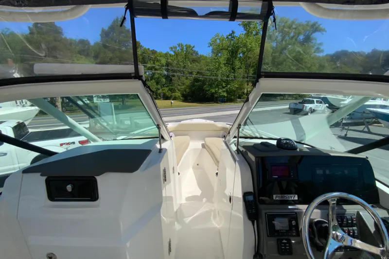 Slide: The Image of 2021 Pursuit DC 266 Dual Console boat interior with steering wheel and dashboard controls. - 24