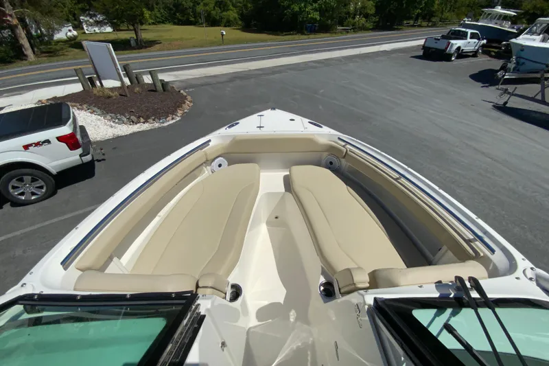 Slide: The Image of 2021 Pursuit DC 266 Dual Console boat with beige seating, parked outdoors. - 25