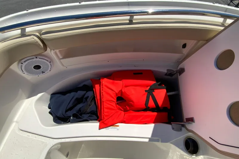 Slide: The Image of 2021 Pursuit DC 266 Dual Console boat storage with life jacket and speaker. - 27