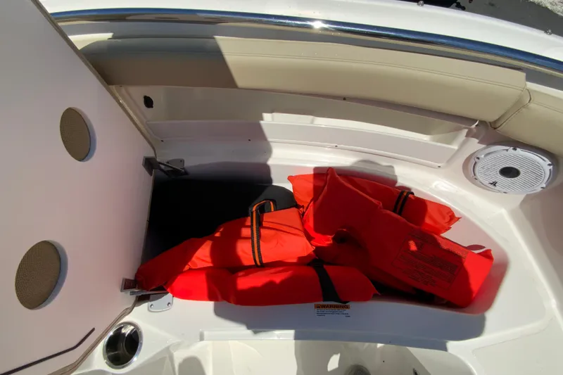 Slide: The Image of Storage compartment with life jackets on a 2021 Pursuit DC 266 Dual Console boat. - 28