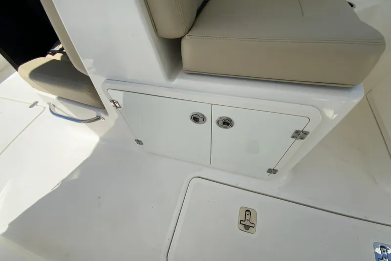 Slide: The Image of 2021 Pursuit DC 266 Dual Console boat interior storage compartment with cushioned seating. - 29