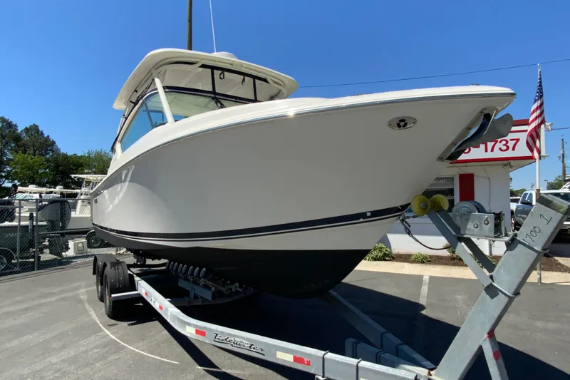 Slide: The Image of 2021 Pursuit DC 266 Dual Console boat on trailer, displayed outdoors under clear blue sky. - 3