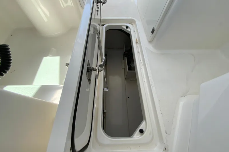 Slide: The Image of 2021 Pursuit DC 266 Dual Console boat storage compartment open. - 31