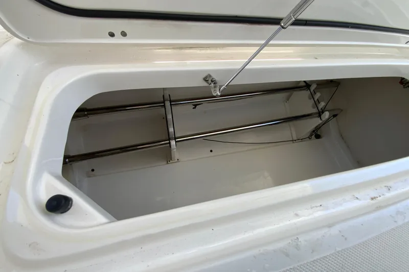 Slide: The Image of Storage compartment of 2021 Pursuit DC 266 Dual Console boat, featuring stainless steel fittings. - 32