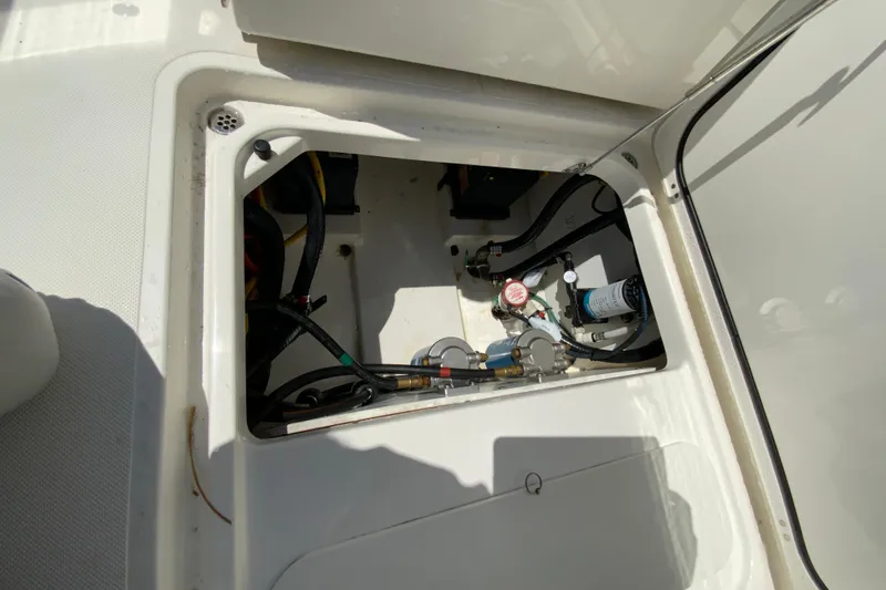 Slide: The Image of 2021 Pursuit DC 266 Dual Console boat compartment with visible wiring and components. - 33