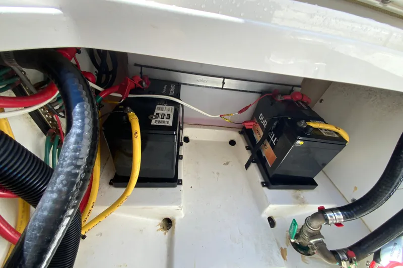 Slide: The Image of 2021 Pursuit DC 266 Dual Console boat battery compartment with wiring and connections. - 34