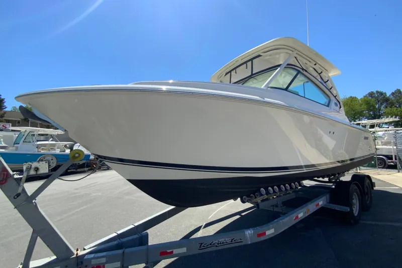 Slide: The Image of 2021 Pursuit DC 266 Dual Console boat on trailer under clear blue sky. - 5
