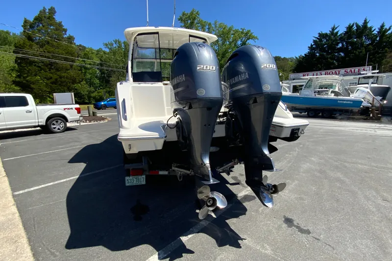 Slide: The Image of 2021 Pursuit DC 266 Dual Console boat with twin Yamaha 200 engines in a parking lot. - 8