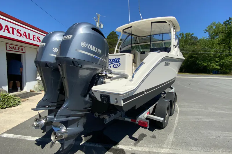 Slide: The Image of 2021 Pursuit DC 266 Dual Console boat with twin Yamaha engines on a trailer. - 9