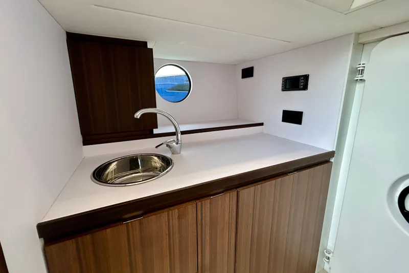 Slide: The Image of Crew galley area in 2024 Aicon Vivere 66 yacht with modern sink and wooden cabinetry. - 114