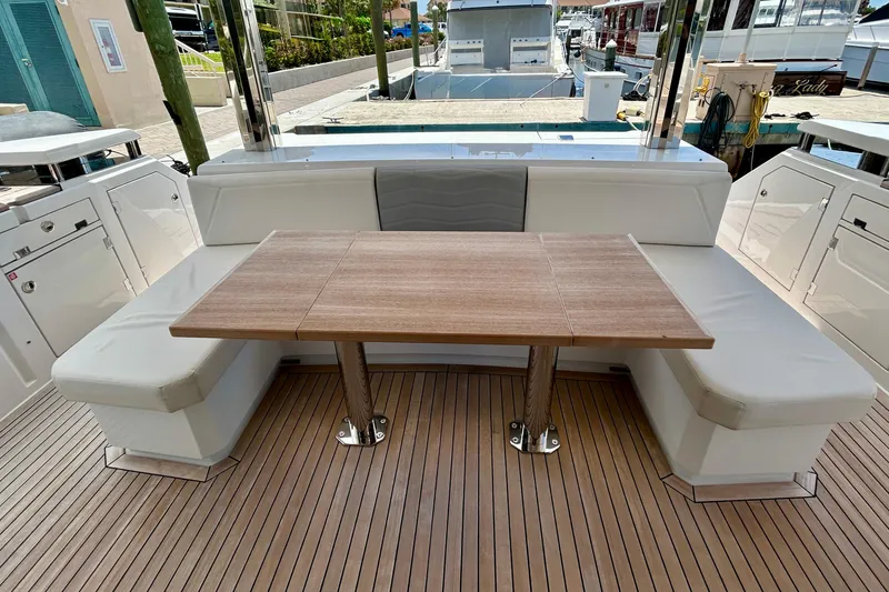 Slide: The Image of Luxury seating area on 2024 Aicon Vivere 66 yacht with wooden table and cushioned benches. - 15