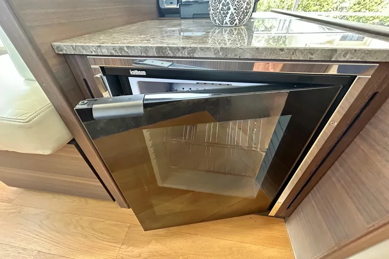Slide: The Image of Open mini fridge in 2024 Aicon Vivere 66 yacht interior, featuring sleek design and wood finish. - 39