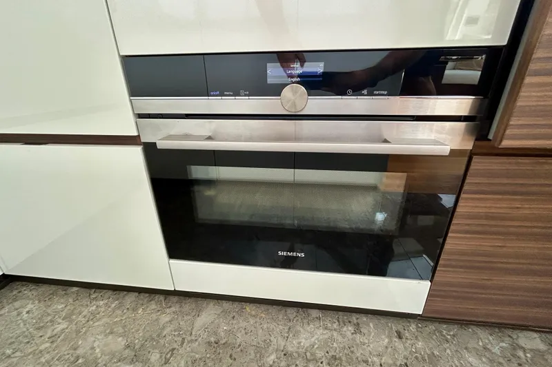 Slide: The Image of Modern Siemens oven with digital display in a sleek kitchen setting. - 49