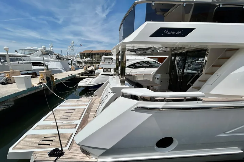Slide: The Image of 2024 Aicon Vivere 66 yacht docked at marina under clear blue sky. - 6
