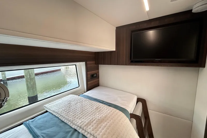 Slide: The Image of Interior of 2024 Aicon Vivere 66 yacht cabin with bed, window, and TV. - 90