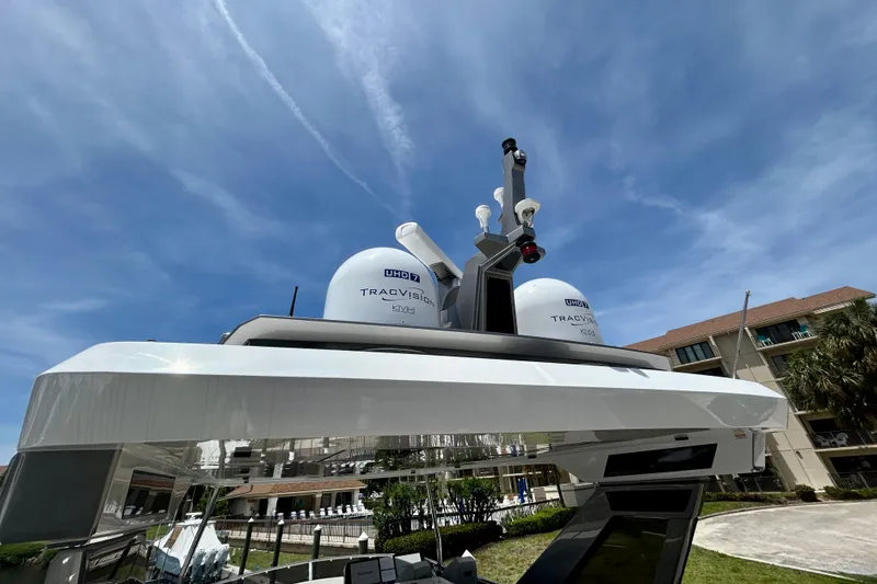 Slide: The Image of 2024 Aicon Vivere 66 yacht with advanced TracVision satellite system under clear blue sky. - 92