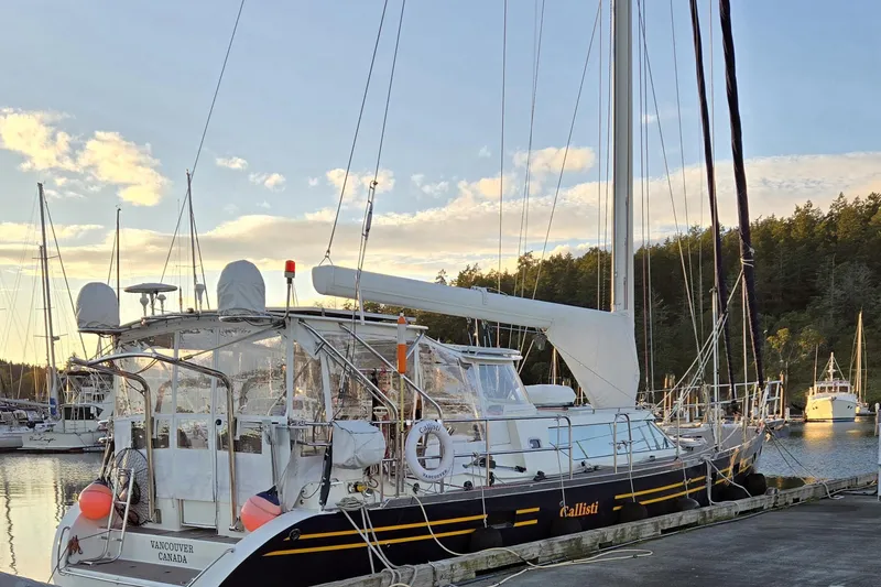 Slide: The Image of Sailboat docked at marina, Waterline 50 model, 2006, with scenic sunset backdrop. - 1