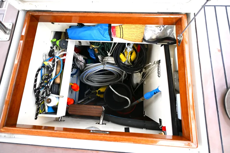 Slide: The Image of Storage compartment on a 2006 Waterline 50 boat filled with ropes and tools. - 105