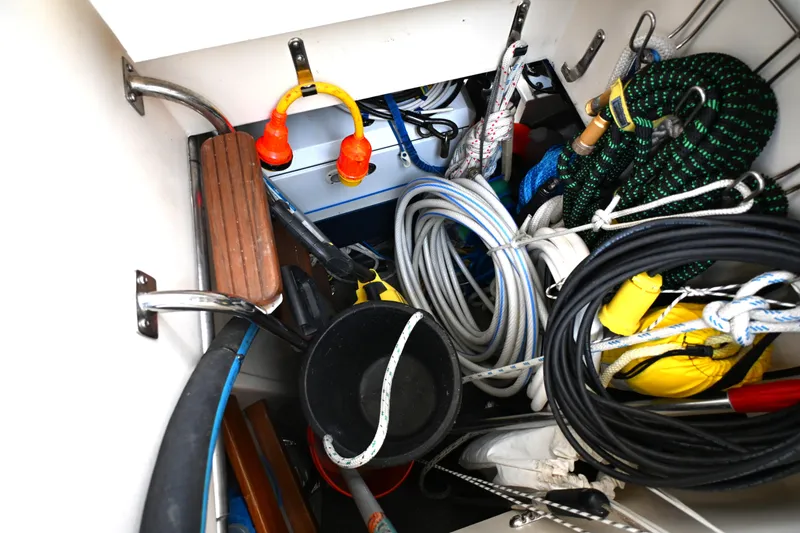 Slide: The Image of Storage compartment on a 2006 Waterline 50 boat, filled with ropes and equipment. - 106
