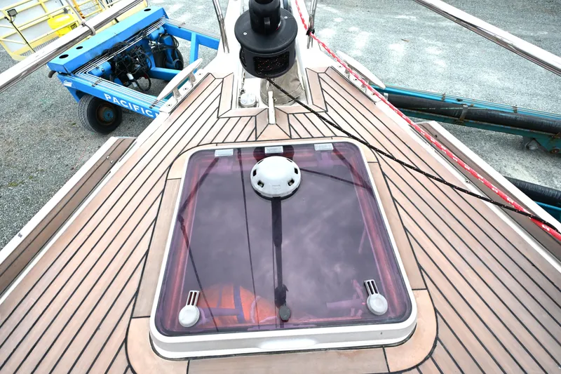 Slide: The Image of Deck of 2006 Waterline 50 yacht with hatch and winch, docked on gravel. - 11