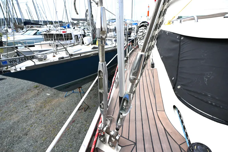 Slide: The Image of Deck view of a 2006 Waterline 50 sailboat in a marina, showcasing rigging and nearby vessels. - 26