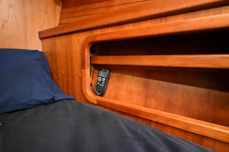 Slide: The Image of Wooden interior of a 2006 Waterline 50 yacht with a built-in shelf and remote control. - 68