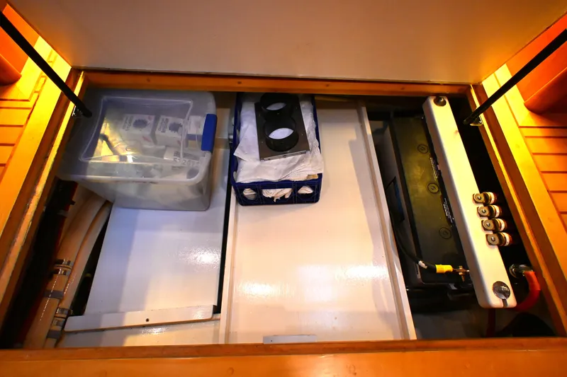 Slide: The Image of Storage compartment in a 2006 Waterline 50 yacht, featuring organized equipment and supplies. - 73