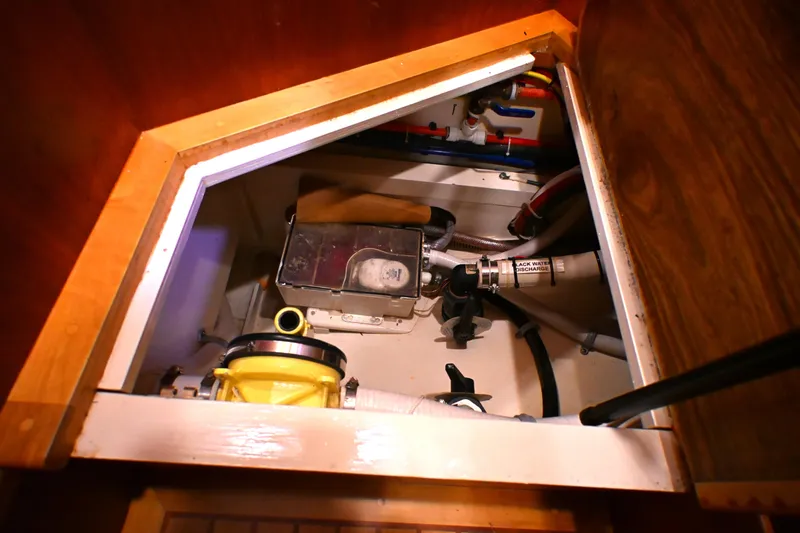 Slide: The Image of Engine compartment of a 2006 Waterline 50 yacht, showcasing plumbing and mechanical components. - 84