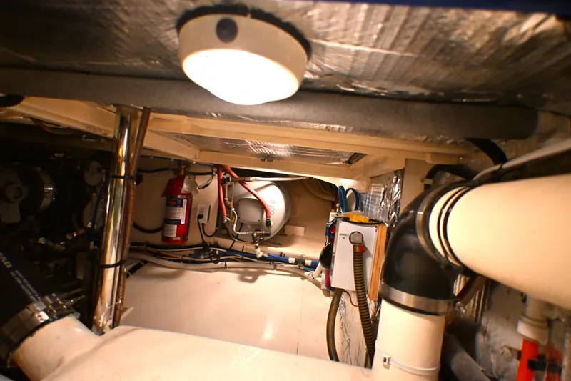 Slide: The Image of Engine room of a 2006 Waterline 50 yacht, featuring pipes and a fire extinguisher. - 87
