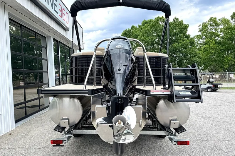 Slide: The Image of 2026 Manitou Aurora RF 23 pontoon boat with outboard motor, parked outside dealership. - 3